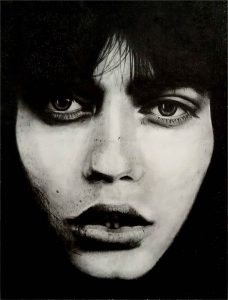 Retrato en carbón de mujer con ojos expresivos y cabello oscuro, dibujo artístico y realista realizados en la escuela de arte de Barcelona.