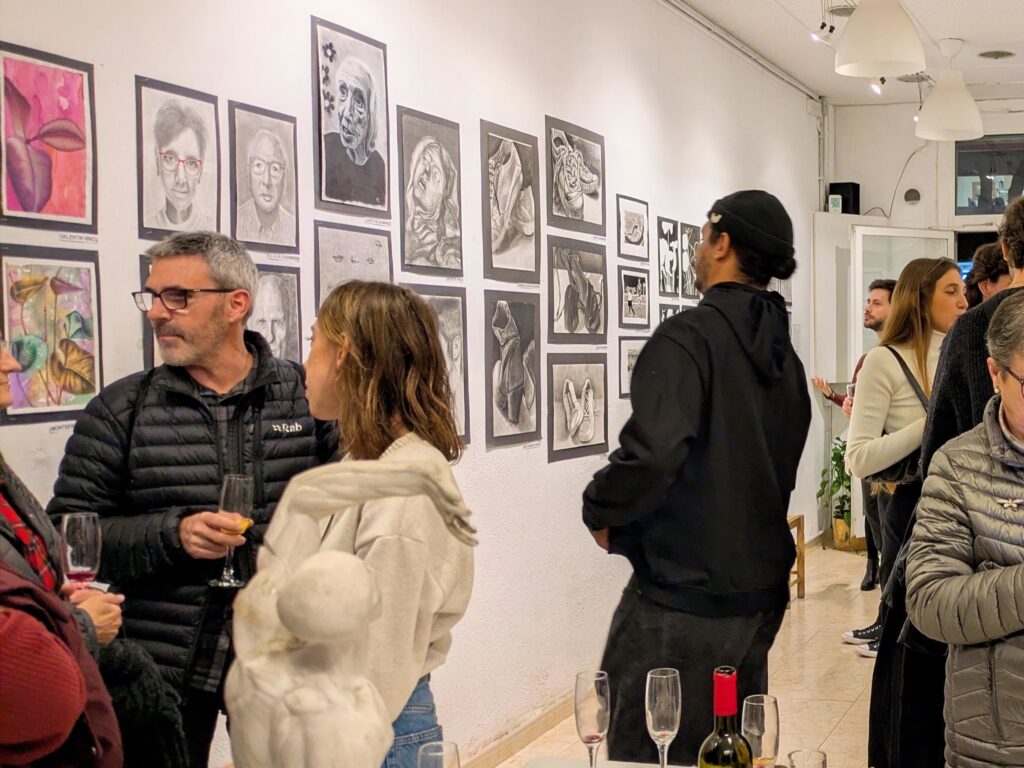 Alumnos y acompañantes en la inauguración de una exposición de trabajos de alumnos principiantes